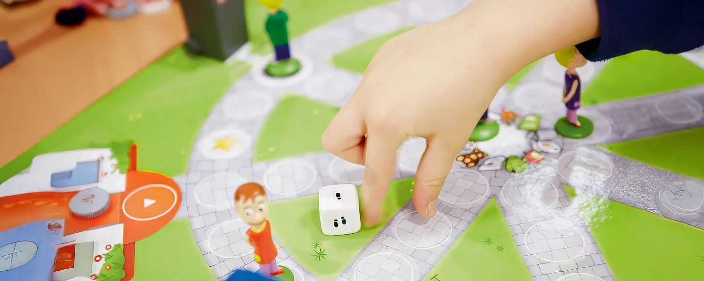 Ein Kind spielt ein Brettspiel zur Kreislaufwirtschaft
