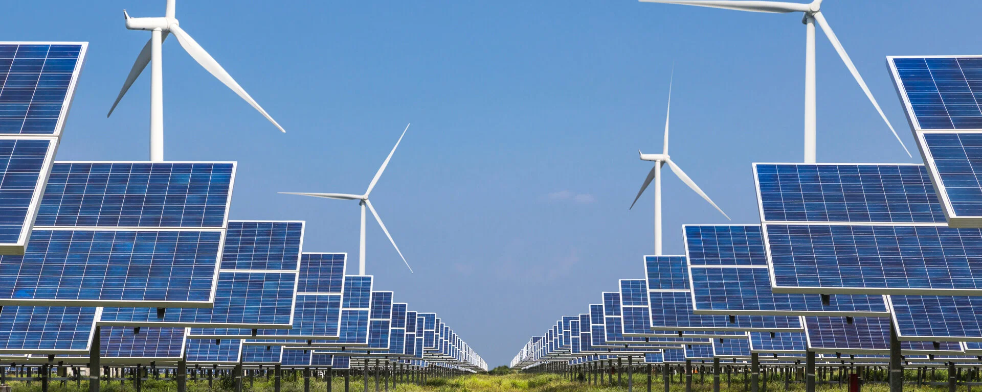 Photovoltaikanlage und Windturbinen auf einem Feld.
