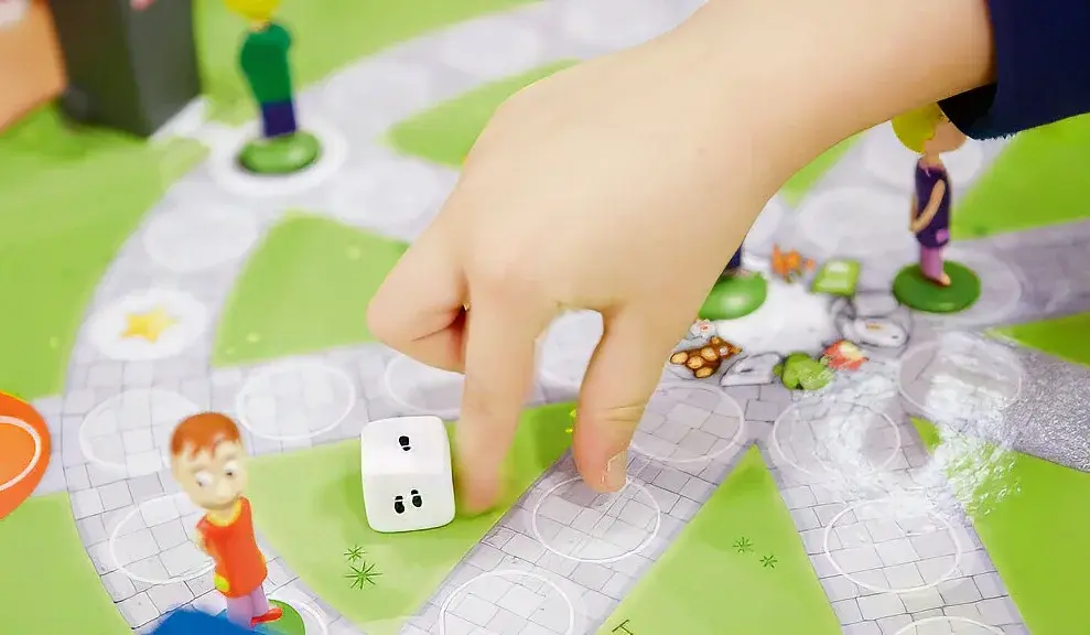 Ein Kind spielt ein Brettspiel zur Kreislaufwirtschaft