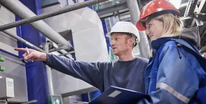 Zwei Mitarbeitende einer Anlage von Remondis prüfen Arbeitsweise.
