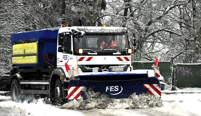 Grossstreuerfahrzeug der FES im Winterdiensteinsatz auf verschneiter Straße